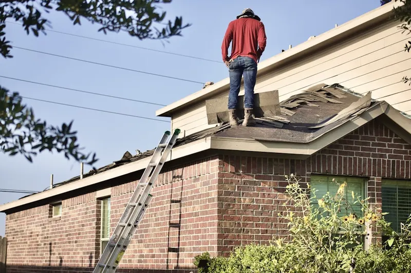 Professional roofer working on a residential roof in Avon Forest